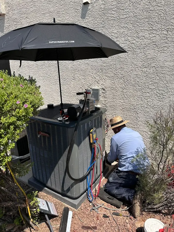 HVAC technician performing outdoor AC maintenance in Layton