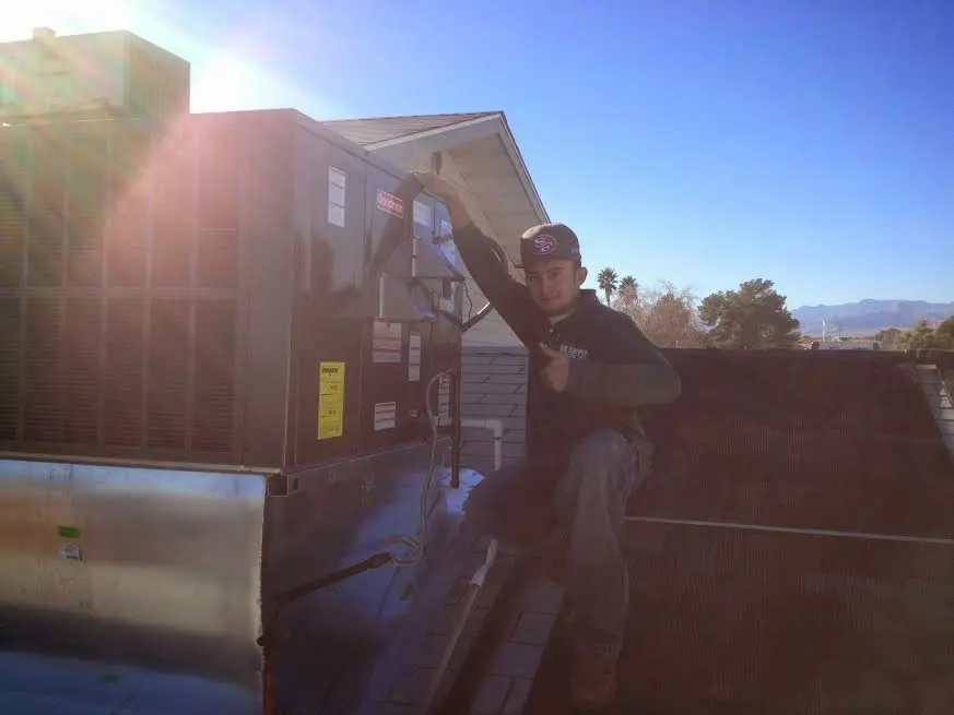 HVAC technician performing HVAC Inspection on a rooftop unit in Layton